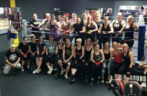 Participants gathered around a boxing ring after training