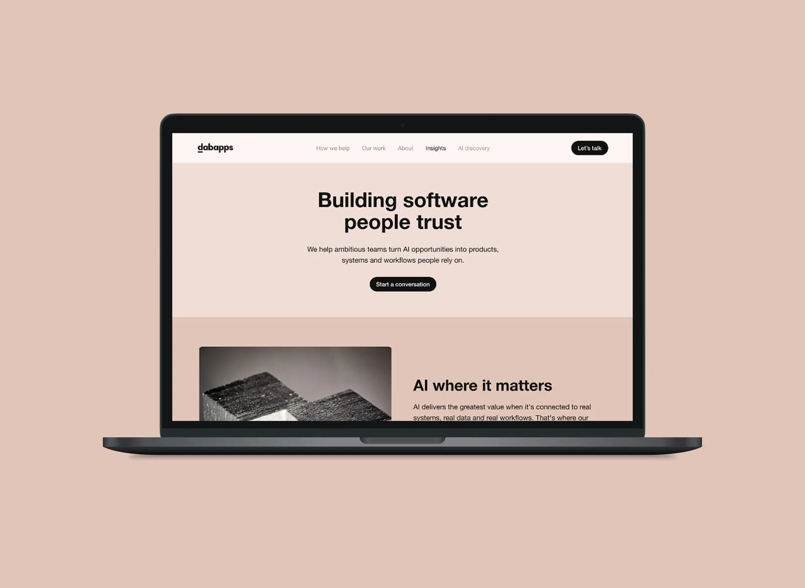 DabApps homepage shown on a laptop against a pale brand background