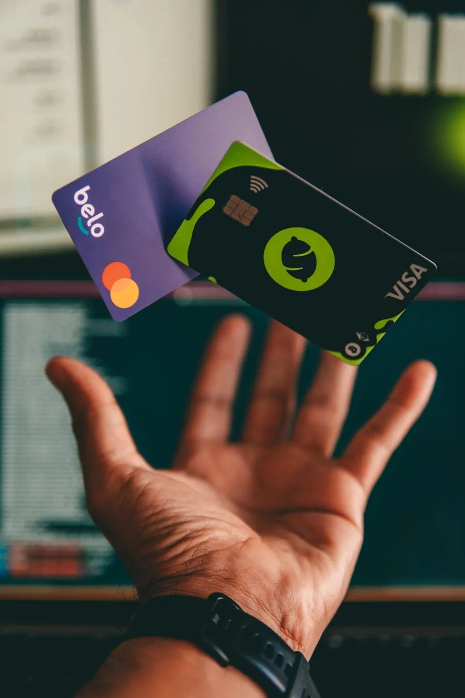 Two payment cards falling towards an outstretched hand