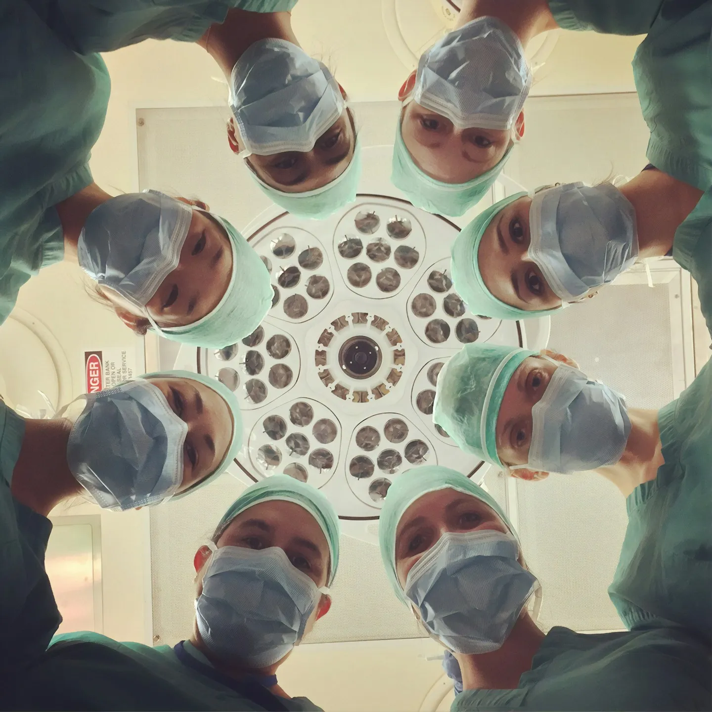A surgical team wearing masks gathered in a circle