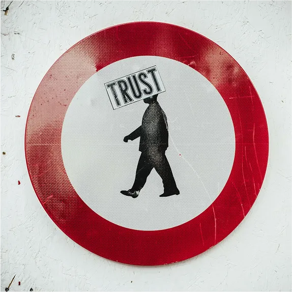 A red-bordered sign showing a walking figure labelled Trust